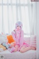 A woman sitting on a bed with stuffed animals.