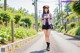 A woman in a school uniform is walking down the street.