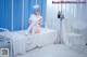 A woman sitting on top of a hospital bed.