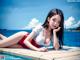 A woman in a red and white bathing suit laying on a dock.