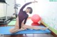 A woman in a black bodysuit is doing yoga on a blue mat.