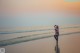 A woman standing in the water at the beach.