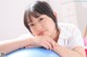 A young girl sitting on top of an exercise ball.