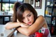 A woman leaning on a counter with her hand on her chin.