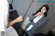 A woman in a business suit is writing on a clipboard.